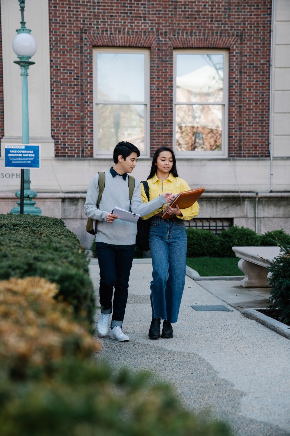 University students walking together and reviewing notes