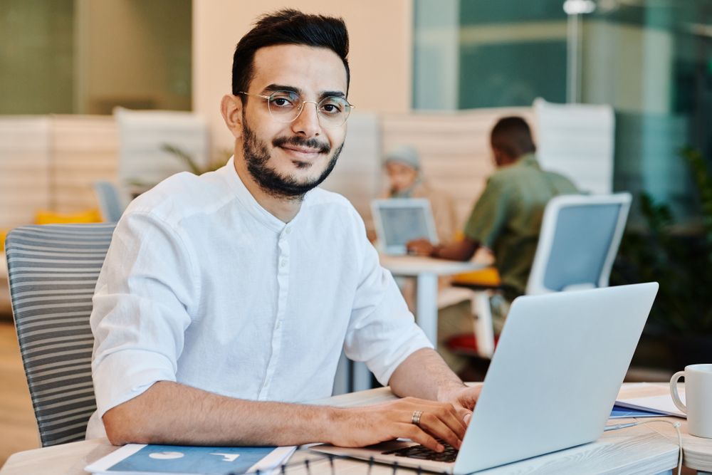Young professional working at a laptop in a bright office